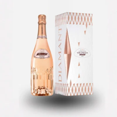 Bottiglia di vino Diamant Rose in primo piano su sfondo luminoso, con calice di vino rosa brillante e perlage fine.